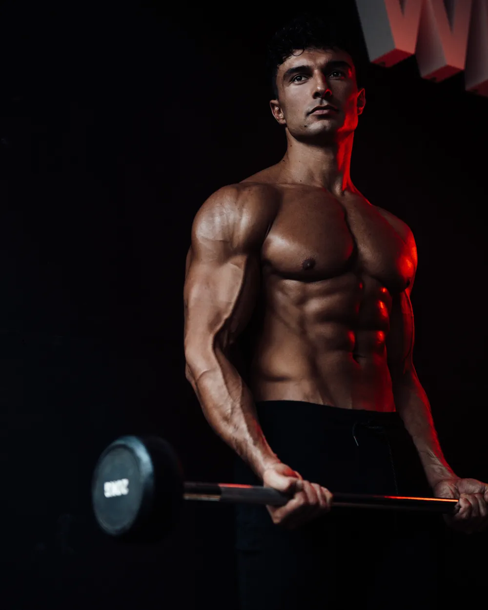 Ugur Cevher met een halterstang in een donkere gym